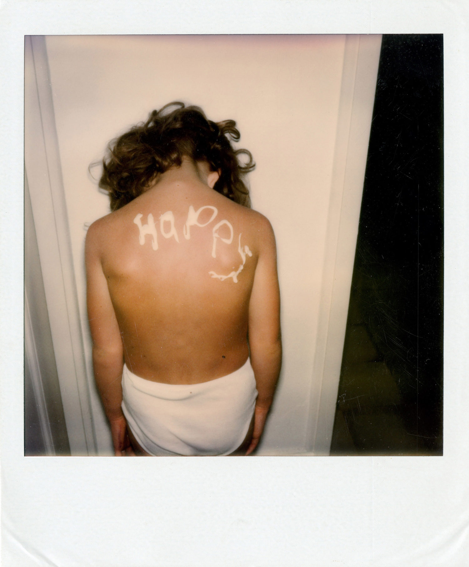 Polaroid of Stella with the word 'Happy' written on her back