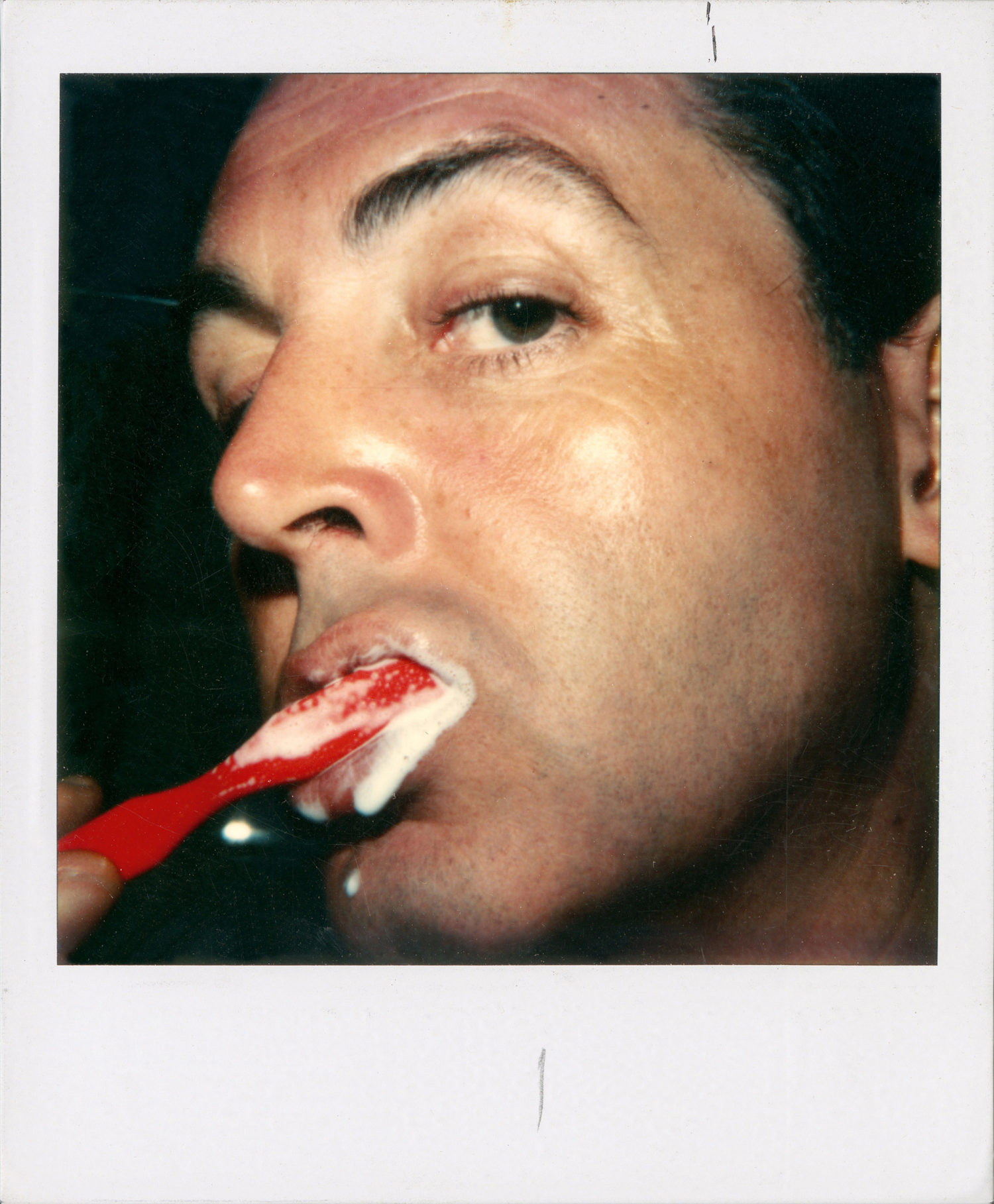 Polaroid of Paul brushing his teeth